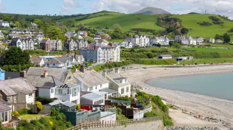 Getty Images Criccieth in Gwynedd. Houses on rolling green hills overlook a pebble beach