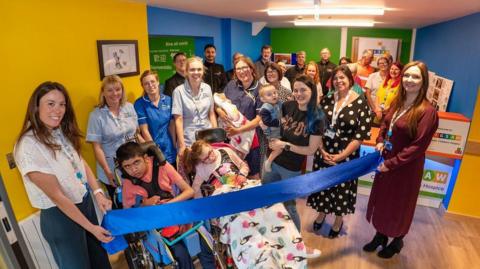 Staff and patients at the hospice standing in the newly bright reception area