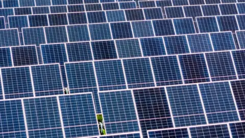 An array of solar panels in a field.