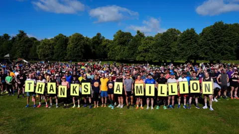 PA Media Elizabeth Duggan, chief executive officer of parkrun Global (centre left) Parkrun founder, Paul Sinton-Hewitt (centre) and Dame Kelly Holmes (centre right) at the Bushy Park Parkrun in London, where the very first Parkrun took place, to mark its one millionth event. 