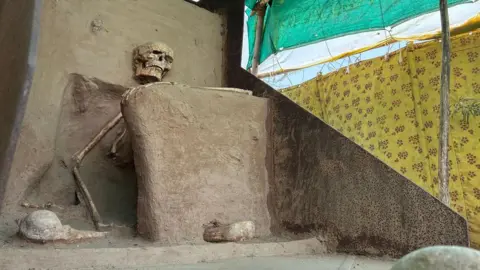 The photo of a skeleton placed inside a make-shift tent covered by yellow and green cloth in Vadnagar town. 