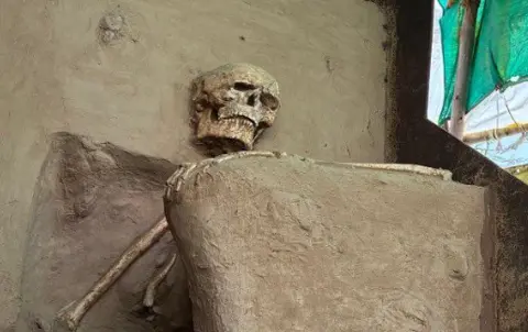 The photo of a skeleton placed inside a make-shift tent covered by yellow and green cloth in Vadnagar town.