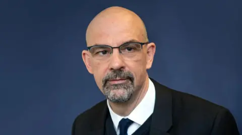 East Midlands Councils Image of Andrew. He is wearing a dark suit and has glasses.