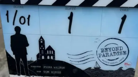 A black and white clapper board for a production of Beyond Paradise 