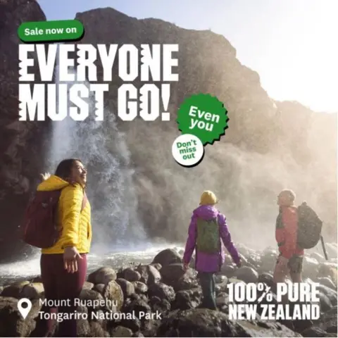 Tourism NZ A poster shows three people in colourful windbreakers and backpacks at a waterfall in Mount Ruapehu, Tongariro National Park, with the words: 'Sale now on. Everyone must go. Even you. Don't miss out. 100% New Zealand.'