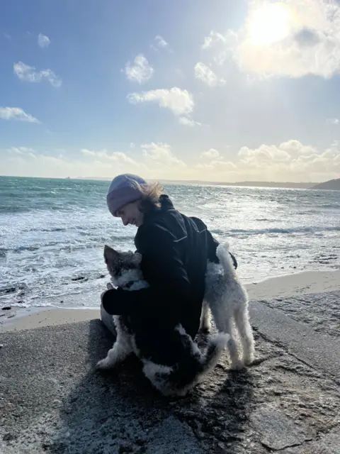 Mark Ballett A woman and her dogs beside the sea