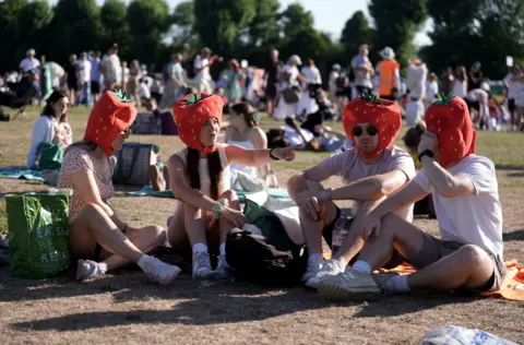fan withs strawberry hats in the queue 