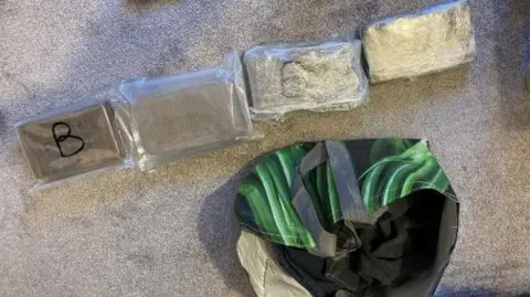 Wiltshire Police A supermarket bag for life next to four plastic-wrapped drug packages.