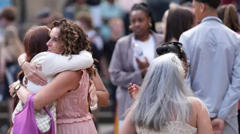 PA Media People hug outside Sheffield Cathedral