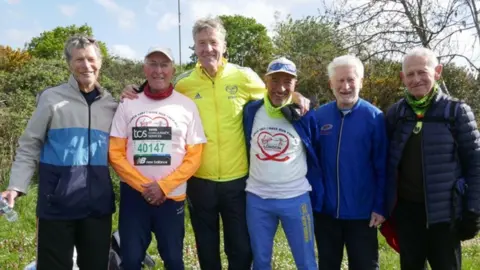 The Ever Presents on marathon day standing in a line smiling