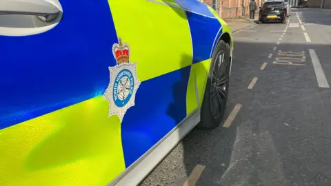 The side of a North Yorkshire Police car on the road.