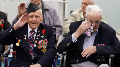 PA D-Day veteran Bernard Morgan (left), 100, from Crewe, salutes as veteran Harry Birdsall, 98, from Wakefield, gets emotional as he travels on the Brittany Ferries ship Mont St Michel
