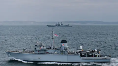 Royal Navy Image shows two ships, in the foreground is Royal Navy vessel HMS Cattistock and in the backround, Russian vessel RFN Severomorsk 619