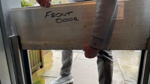 A person inserts flood gates into their front door.