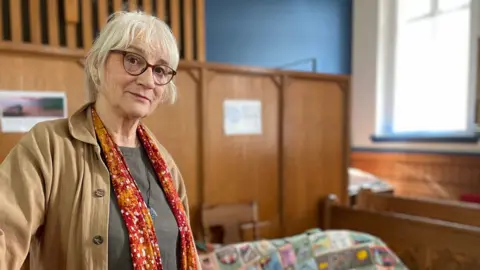 Woman standing in front of a large patchwork coat