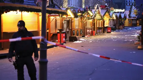 Getty Images A police officer walks through the closed Christmas market the day after a terrorist attack that killed five people, including a small child, and injured over 200 in Magdeburg on December 21, 2024.