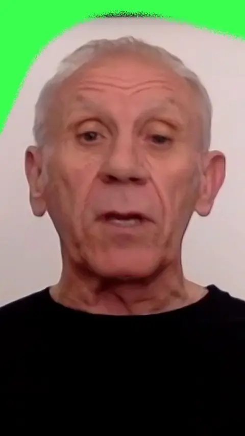 Former England midfielder Peter Reid. He is wearing a black shirt.