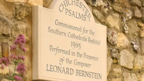 Chichester Cathedral A plaque to Leonard Berntein on the side of a brick wall