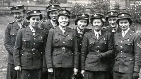 Christina Hartnell A black and white photograph of Christina Hartnell in uniform with seven other women.