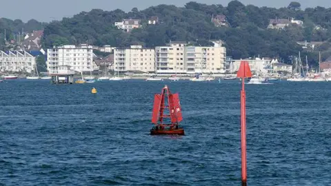 David Dixon A red metal marker buoy in Poole Harbour