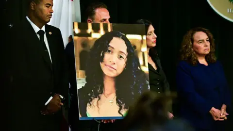 A portrait of the late Celeste Rivas Hernandez is shown during a press briefing by Los Angeles County District Attorney Nathan J. Hochman (out of frame) on the case against singer D4vd in Los Angeles, on April 20, 2026. 