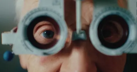 Association of Optometrists Close up image of an elderly man having his eyes tested by an optometrist
