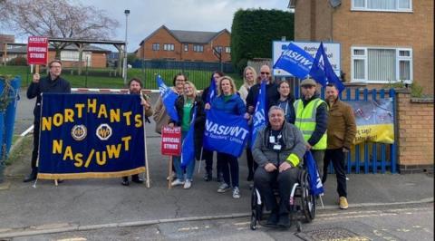Teachers on a picket line outside school, with NASUWT banners