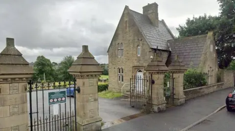 A two-storey stone building with an iron gated entrance