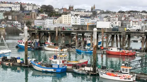 BBC Small boats on the harbour with buildings in the background