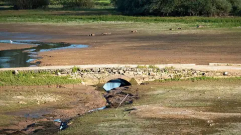Getty/Matt Cardy Bridge in empty lake. There is a trickle of water going through it because of a drought. Usually this would be full of water.