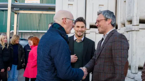 The Carbon Removers Two men in suits shake hands 