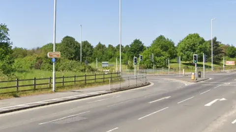 Google A road junction with a brown sign which reads: "Canford Park Arena"