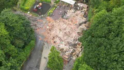 PA Media Aerial view of the rubble left behind after the demolition of the Crooked House