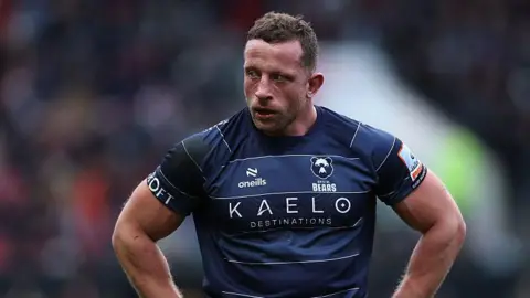 Max Lahiff stands with his hands on his hips on the pitch during a match for Bristol