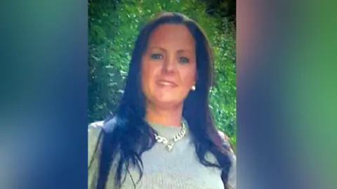 South Wales Police Victoria Thomas saw the camera and smiling. He has black hair straight under her shoulder and is wearing a thick gold chain over a green flicker