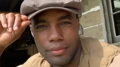 Reece Richards wearing a hat, looking at the camera 