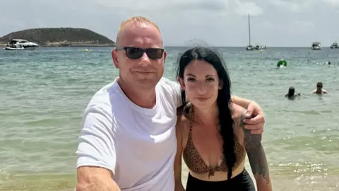 Adam and Charlotte pictured on the beach 