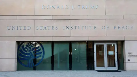 Getty Images President Donald Trump's name is seen placed on the outside of the United States Institute of Peace (USIP) building headquarters on 3 December 2025 in Washington DC 