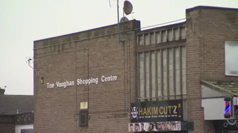 BBC A brick built building with a sign saying The Vaughan Shopping Centre 
