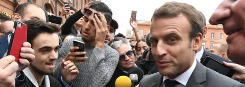 AFP French President Emmanuel Macron speaks with people at the Place du Capitole in Toulouse, southern France
