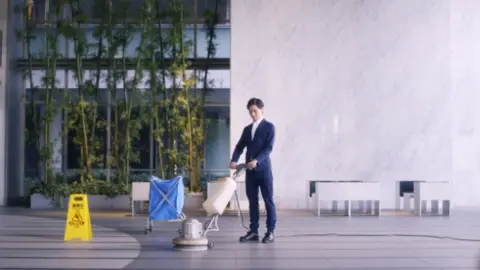 Oasys Lifestyle Group A cleaner in an Oasys business suit