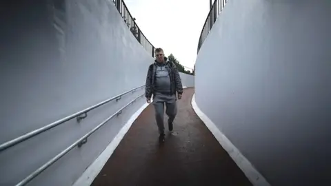 Man walking down underpass