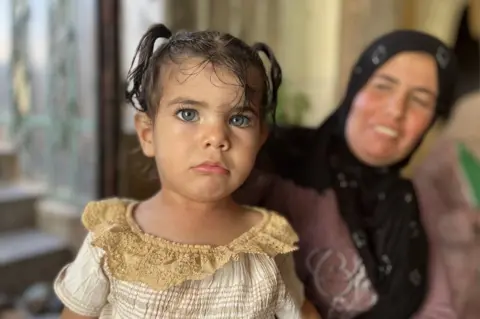 A girl forcibly removed from al-Qabun, with her mother, Nida