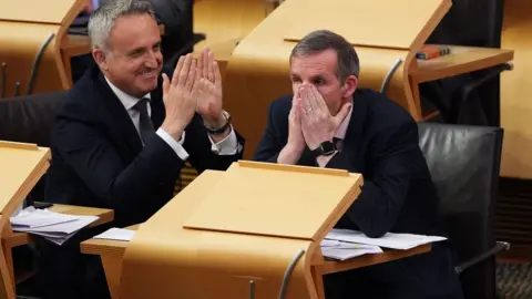 MSP Liam McArthur has his head in his hands as he finds out his bill on assisted dying has passed stage one
