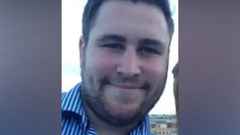 A photo of Ashley, wearing a blue and white striped shirt.