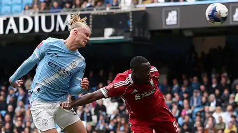 Erling Haaland fends off Ibrahima Konate to score his second goal against Liverpool
