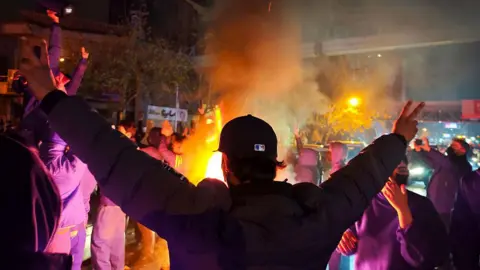  Fires are lit as protesters rally on January 8, 2026 in Tehran, Iran. 