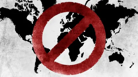 A world map graphic with a red denied symbol on top