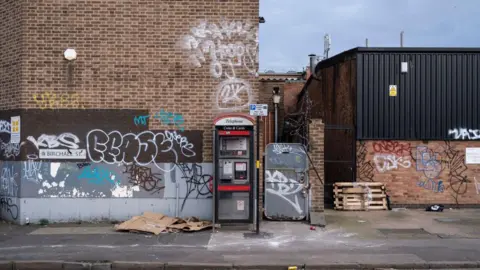 Getty Images Graffiti covered street corner with rubbish strewn about outside an old industrial factory building in Birmingham