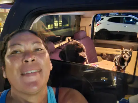 Felicia Johnson is a personal photo of Felicia Johnson showing the same woman, in addition to her car with two dogs inside